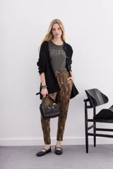 Pantalón babucha con estampado animal print en tonos marrones y negros. Tiene bolsillos diagonales, cintura elastizada y cordón de ajuste.