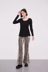 Remera de manga larga entallada en color blanco, confeccionada en algodón. Presenta cuello redondo con una hilera de botones frontales y un pequeño bolsillo en el pecho con detalle de botón.