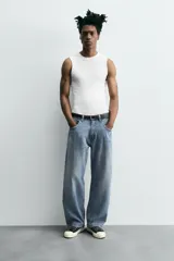 Pantalón de jean gris oscuro, corte amplio, con cinco bolsillos, efecto lavado y cierre frontal con cremallera y botón.