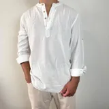 Camisa blanca de manga larga con cuello mao y abertura frontal con botones de madera. Tejido ligero con textura de lino.