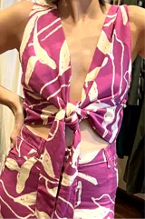 Top morado con estampado de flores blancas, escote en V y lazo en la cintura. Confeccionado en lino.