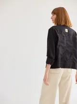 Chaqueta color marrón claro de lino y algodón, con cuello mao, cierre frontal con botones de madera y bolsillos laterales.