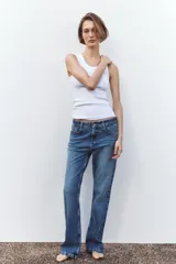 Pantalón de jean azul de tiro alto, corte bootcut, con cinco bolsillos, cierre frontal con cremallera y botón.