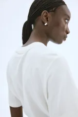 Remera blanca de corte holgado en punto de algodón. Modelo con cuello redondo y estampado de limones con texto en el frente.