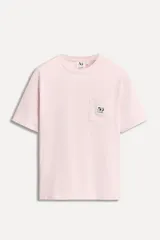 Camiseta negra de algodón con cuello redondo y manga corta. Tiene un bolsillo de parche en el pecho con el logo del 50 aniversario.