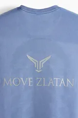Remera deportiva azul de manga corta con cuello redondo, sección de malla en laterales y espalda, diseño reflectante en el pecho y atrás, y bajo recto. Corte musculoso con silueta entallada que realza el torso.