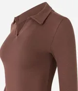 Blusa color crema de rib de algodón, con cuello polo y mangas largas.
