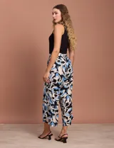 Pantalón capri estampado con flores en tonos azul, blanco y negro. Tiene pretina elastizada en la parte trasera y bolsillos delanteros.