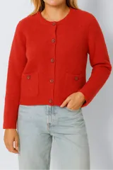 Cárdigan rojo de punto con cuello redondo, mangas largas, cierre frontal con botones y bolsillos de parche.