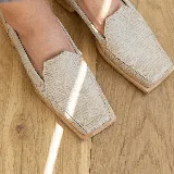 Mocasines negros de cuero con textura tipo reptil, punta cuadrada y detalle de aplique de cuero liso en el empeine.