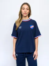 Remera azul con cuello y puños tricolor (azul, blanco y rojo), logo de Umbro bordado en blanco y escudo del Club Nacional de Football bordado en el pecho.