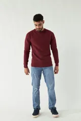 Sweater mostaza de punto con cuello redondo, mangas largas y logo bordado en el pecho. Corte slim fit.