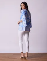 Blusa azul con estampado floral blanco, de seda fría, con cuello redondo con abertura y mangas 3/4 amplias con volados. Marca Ruby Rd.