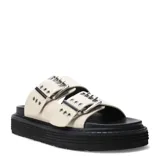 Sandalias planas color crema con doble tira ancha y hebillas metálicas plateadas. Plataforma plana color negro con suela dentada.