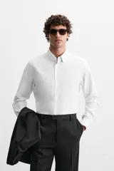 Camisa de vestir verde oscuro, corte slim fit, con cuello italiano, mangas largas con puños abotonados y cierre frontal con botones.