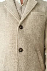 Abrigo masculino Don Baez confeccionado en lana sin teñir, con cuello con solapa, manga larga y forro. Tiene bolsillos y cierre frontal con botones.