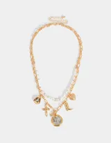 Collar corto dorado de doble cadena, una de eslabones y otra de perlas sintéticas. Incluye dijes de cruz, bota cowboy, moneda antigua y otros.