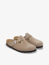 Zueco Birkenstock Boston color beige con remaches plateados, plantilla anatómica de corcho y látex, y capellada de cuero gamuzado.