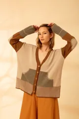 Cárdigan con diseño de bloques de color en tonos beige, marrón y verde, con cuello en V y cierre abotonado.