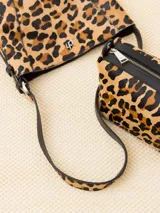 Cartera tote de cuero con estampado animal print, detalles en cuero vacuno y forrería de cuero. Incluye sobre desmontable con cierre y apliques metálicos con logo de la marca.