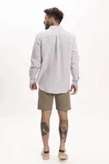 Camisa de manga larga con cuello abotonado y estampado a rayas verticales.