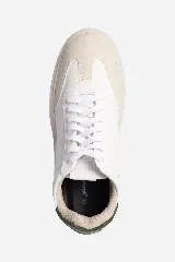 Zapatillas urbanas blancas con detalles en cuero color crema y talón en cuero verde oscuro.