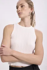 Musculosa negra de tejido de punto acanalado, con cuello redondo y sisas amplias.