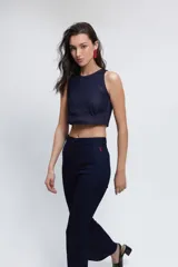 Pantalón de jean azul oscuro, de corte semi oxford con abertura en la parte inferior y pespuntes rojos.