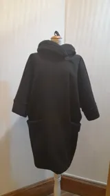 Chaquetón negro de lana tipo astracán, modelo oversize con cuello y puños de piel sintética. Cierre con un botón. Talle único hasta 2XL.