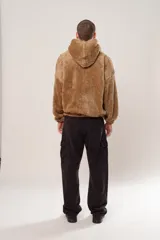 Hoodie beige de piel de corderito sintético, corte oversize con cierre central al estilo anorak, capucha con cordón ajustable y bolsillo canguro.
