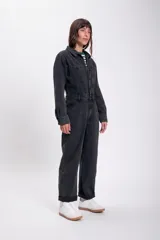 Mono largo de jean negro con corte holgado, mangas largas y cuello camisero.