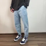 Pantalón jean celeste de corte slouchy, con tiro alto y largo al tobillo.