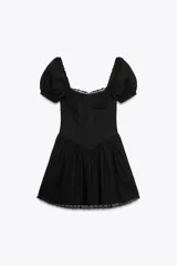 Vestido corto negro de popelín con escote cuadrado, mangas cortas abullonadas, bolsillos laterales ocultos y detalle de encaje a tono.