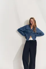 Camisa celeste de algodón con efecto denim, cuello bobo, escote pico, manga larga con puños y cierre frontal con botones.