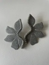 Par de aros con forma de flor roja brillante y detalle de strass plateado en el centro.