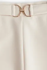 Pantalón sastre color crema de punto crepé con pinzas, tiro alto, cintura elástica, cinturón decorativo con hebilla de metal y piernas amplias rectas.