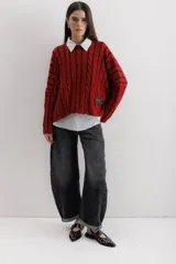 Pantalón de jean negro con corte amplio y ruedo doblado.