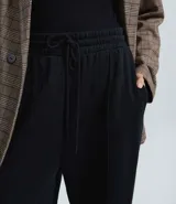 Pantalón wide leg color marrón, confeccionado en algodón con felpa. Presenta cintura elástica con cordón ajustable y bolsillos laterales.