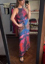 Vestido largo con estampado abstracto en tonos rosa, azul y marrón. Diseño con cuello halter y corte recto.