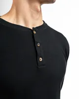 Remera de manga larga gris claro, confeccionada en tejido mini piqué de algodón. Presenta cuello redondo con abertura de tres botones.