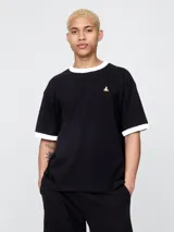Remera negra de manga corta con cuello redondo y ribete blanco en cuello y mangas. Tiene un pequeño bordado de un oso en el pecho.