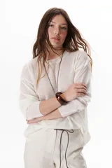 Sweater beige de tejido fino y mangas largas.