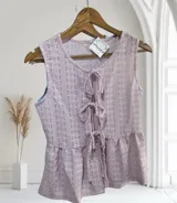 Blusa sin mangas de encaje con detalle de lazo en el escote y corte peplum.