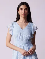 Vestido midi celeste de gasa estampada, marca Julia Jordan. Tiene escote en V, mangas cortas con volados y forro interno a tono.