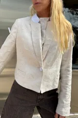 Blazer color crema con bordado a tono, corte sastrero, cuello mao blanco y botón forrado.