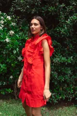 Vestido corto rojo de lino con cuello mao fruncido, volados en los hombros, caída recta y botones al frente.