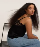 Blusa de satén negra con breteles finos y detalles de encaje en el escote.