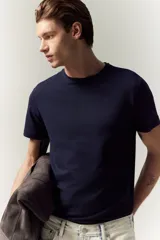 Remera azul marino de punto de algodón liviano, con cuello redondo ribeteado y bajo recto. Corte ajustado que realza el contorno del cuerpo creando una silueta entallada.