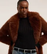 Suéter negro de punto con cuello redondo y mangas largas. Presenta rayas verticales texturizadas y tejido con hilos metalizados.