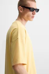 Camiseta de algodón de peso ligero, color verde musgo con efecto lavado, corte boxy fit y cuello redondo.